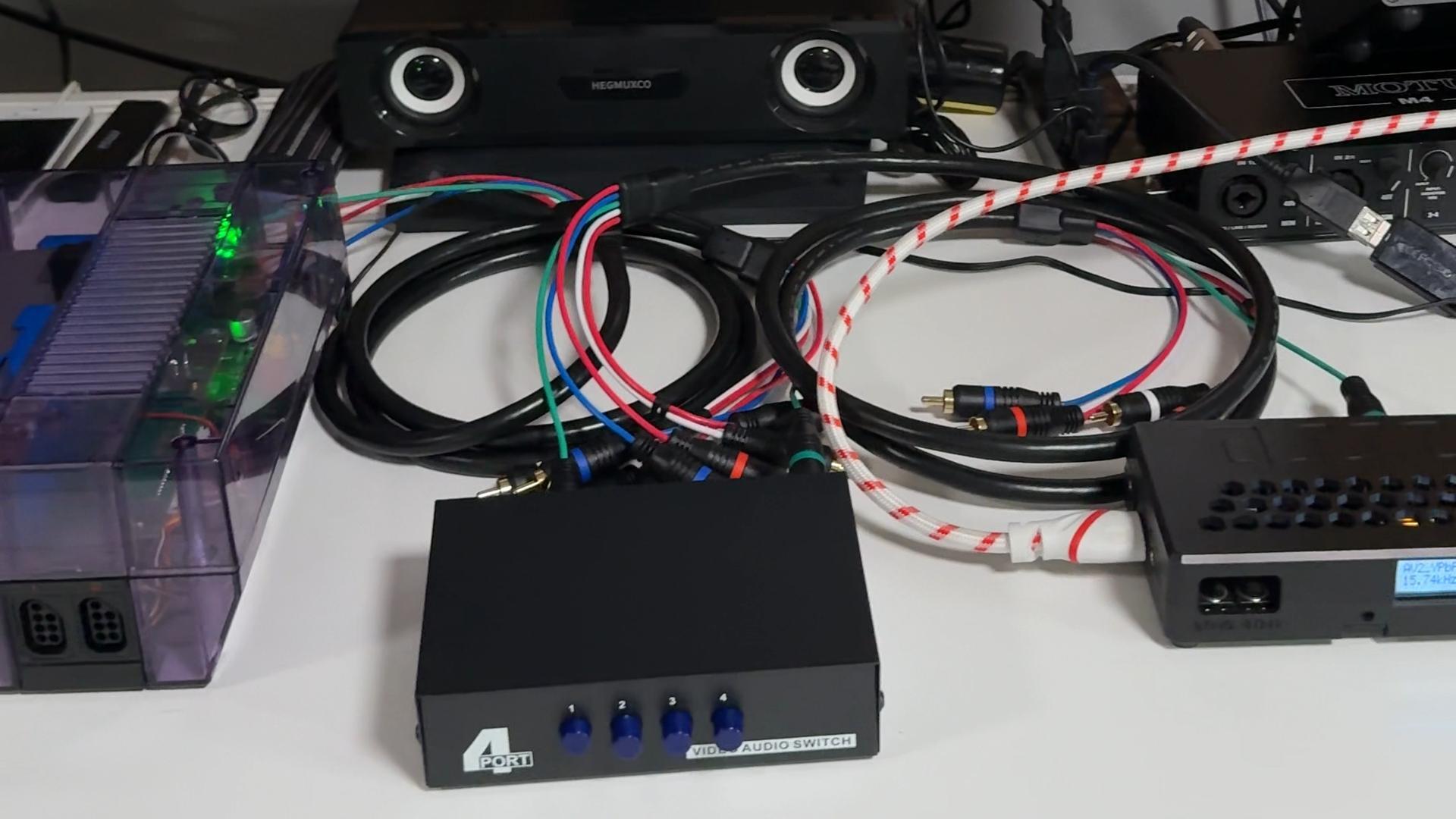 A retro gaming setup with a modded NES connected through A/V cables and a switch box.
