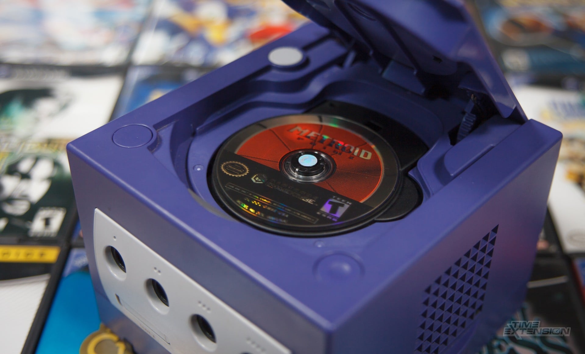 A stack of classic console discs beside a PC Blu-ray drive.